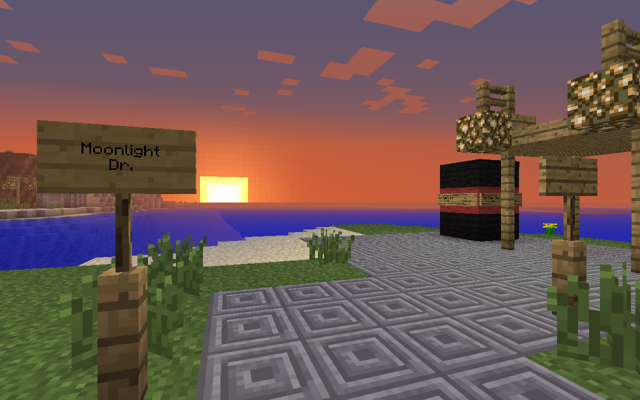 Sonnenuntergang am Meer mit Wegweiser „Moonlight Dr.“ und gepflastertem Platz mit Laternen
